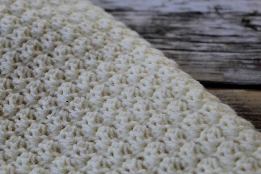 Close up of a cream colored crochet lap blanket, called the Ferguson Lap Blanket.