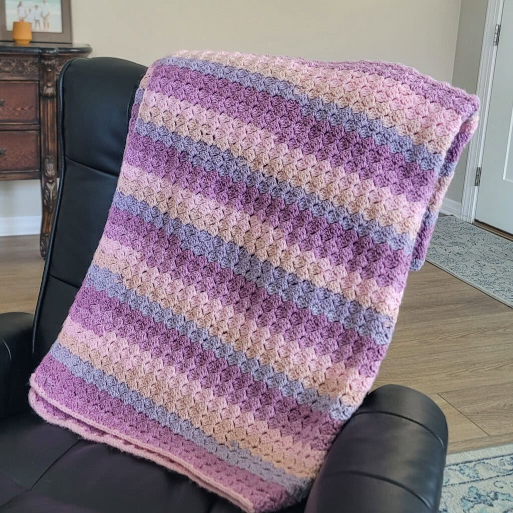 Dallas crochet blanket laid over a chair. 