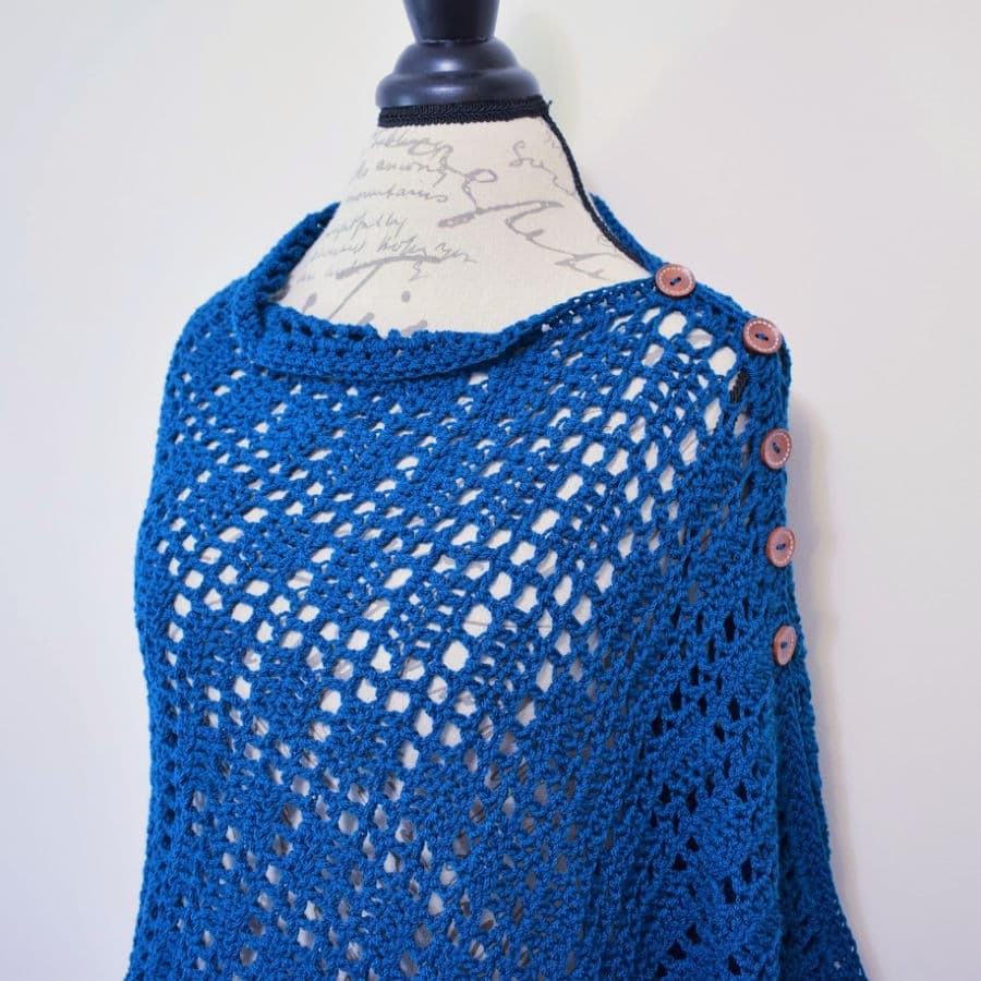 Teal poncho style wrap with buttons down the shoulder. 