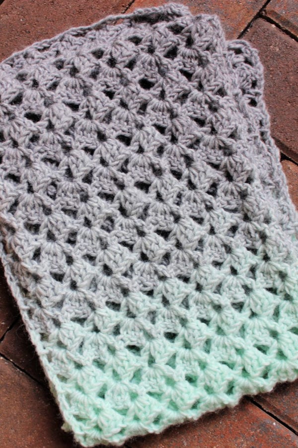 Flat lay of mint green and light gray scarf called the Delightful Scarf. 
