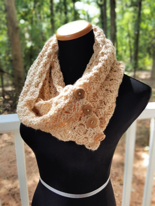 Cream colored crochet infinity scarf with buttons, called the Dallas Scarf. 