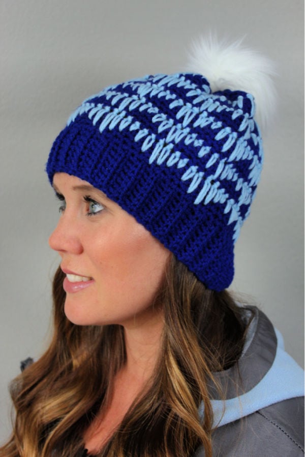 Woman wearing blue crochet hat called the Heartbeat Hat. 