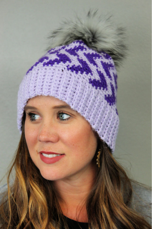 Woman wearing purple crochet hat, called the Halifax Hat. 