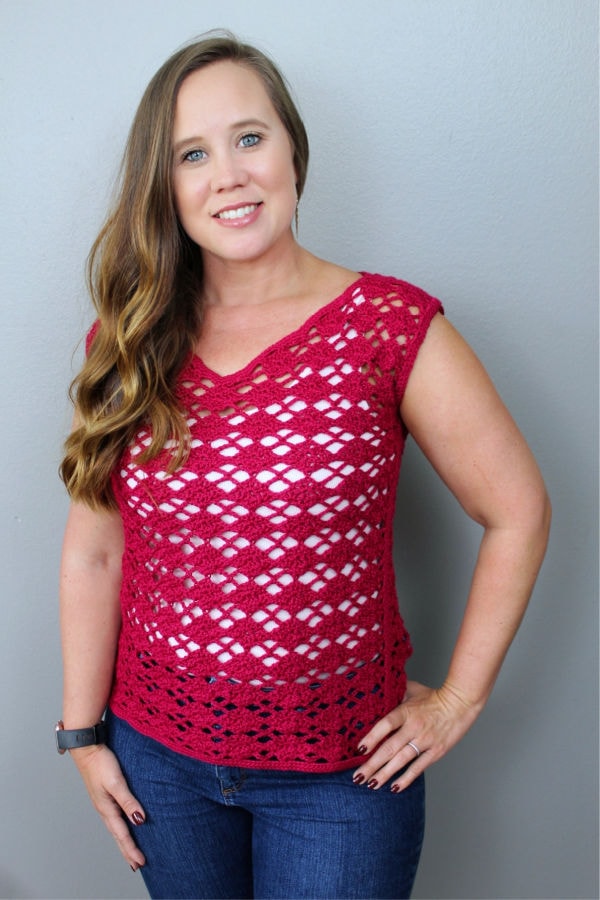 Woman wearing a pink lacy summer crochet top, called the Lacy Top. 