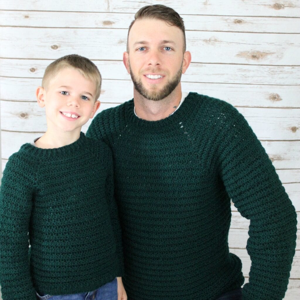 A Father and Son both wearing a crochet pullover sweater, called the Dude Sweater. 