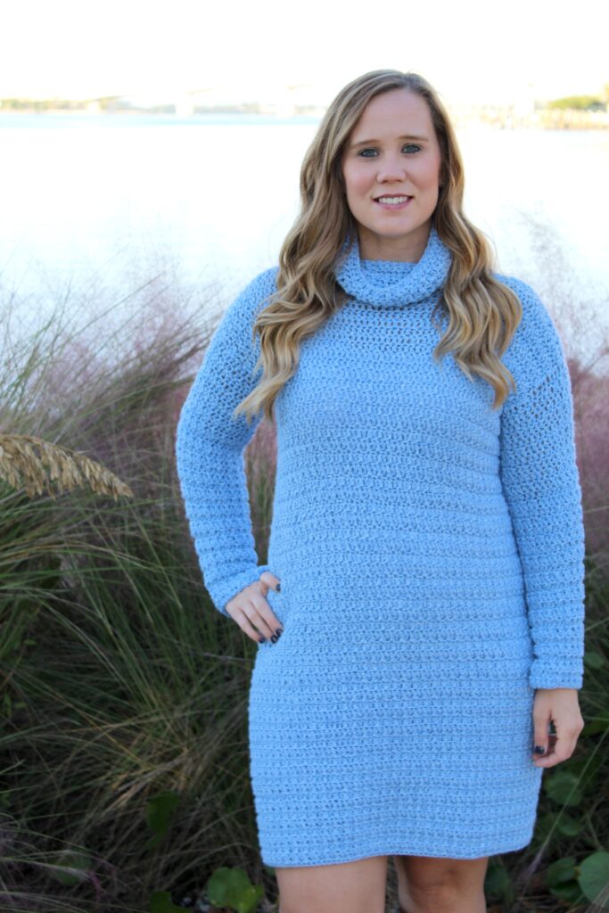 Woman wearing blue crochet dress, called the Edgewater Sweater Dress. 