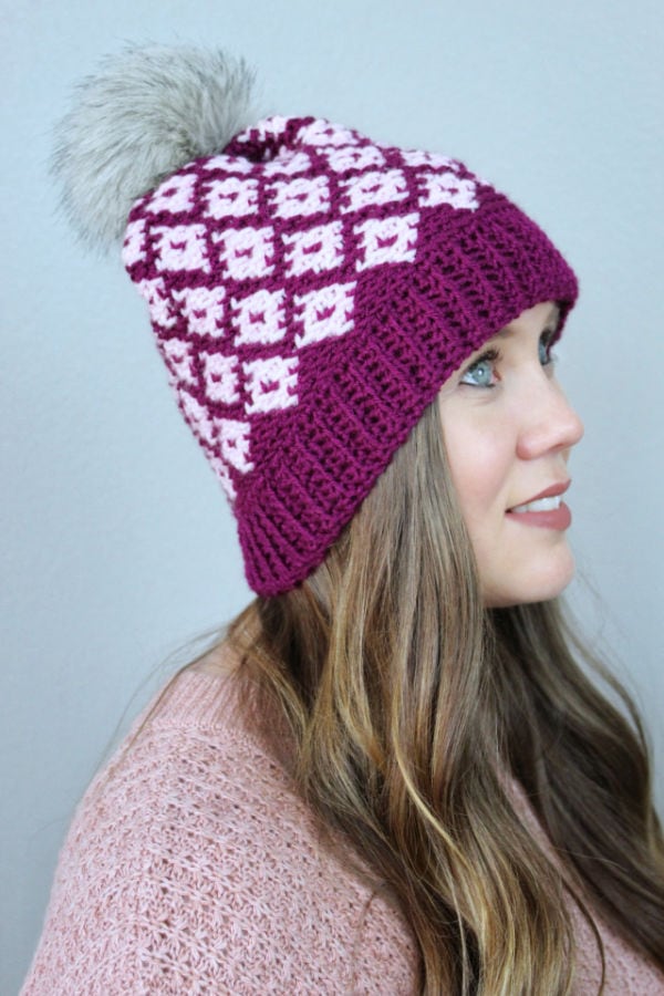 Women wearing a pink fair isle crochet hat, called the Illusion Hat. 