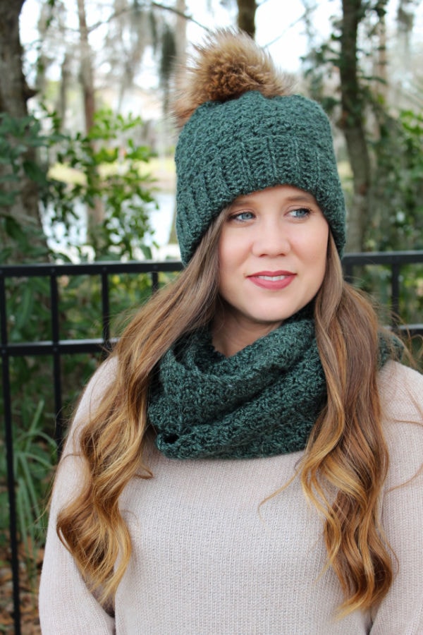 Woman wearing a green crochet hat and matching crochet scarf. 