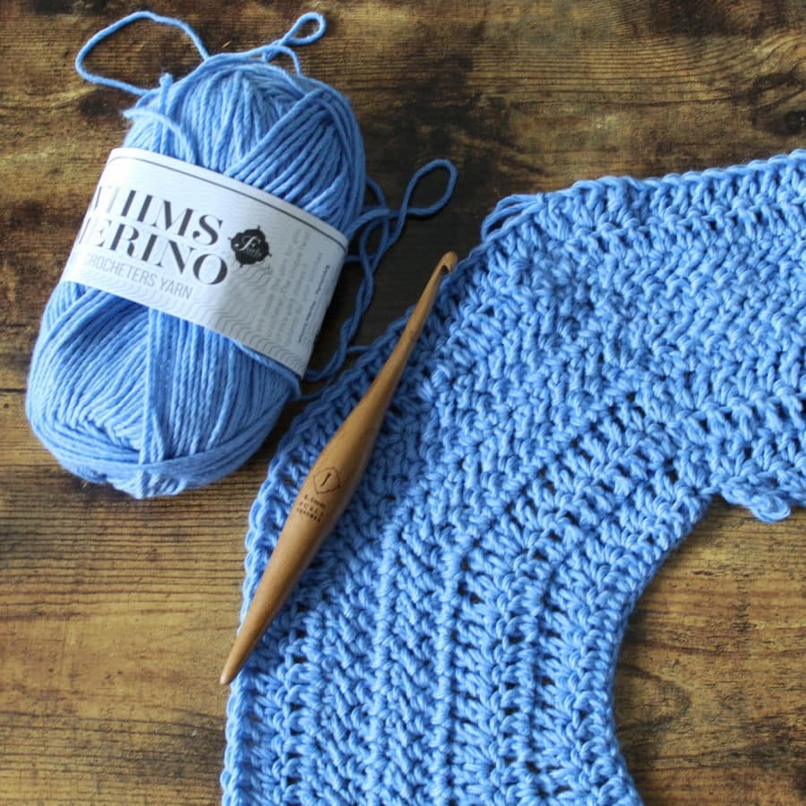 Close up photo of Whims Merino yarn and a Furls Crochet hook.