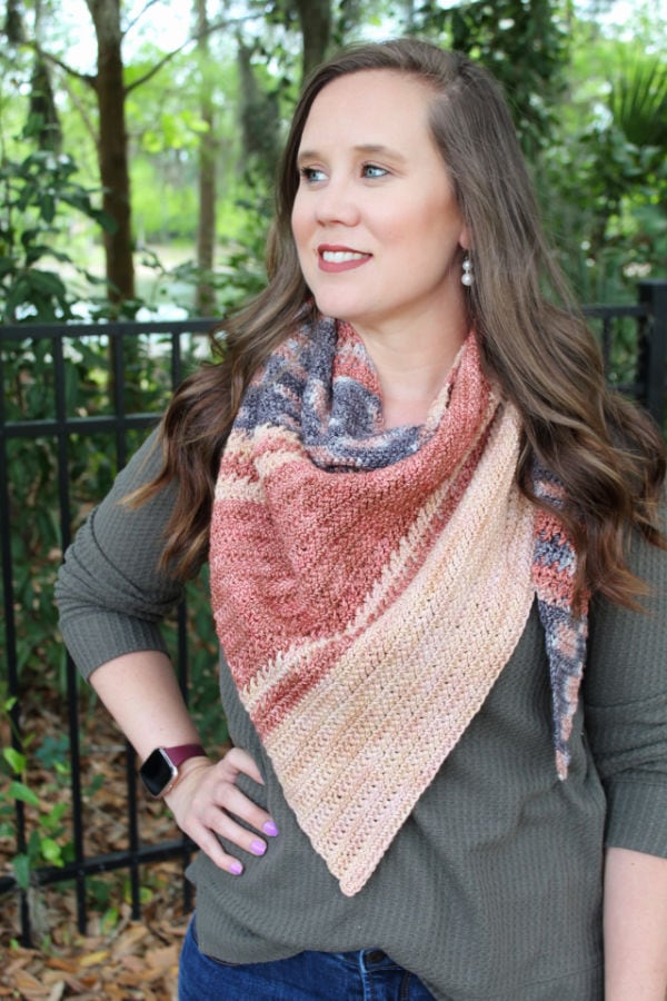 Woman wearing multicolored crochet shawl called the Amara Shawl. 