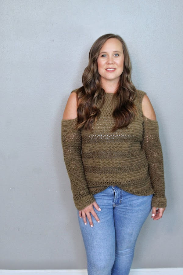 Woman wearing a crochet sweater called the Calgary Cold Shoulder pattern.