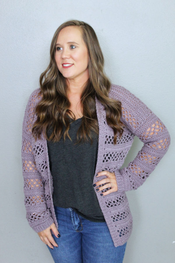 Woman wearing a crochet cardigan called the Magnolia Cardigan. 