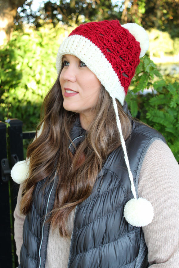 Woman wearing a red and cream crochet slouch hat, called the Sadie Slouch