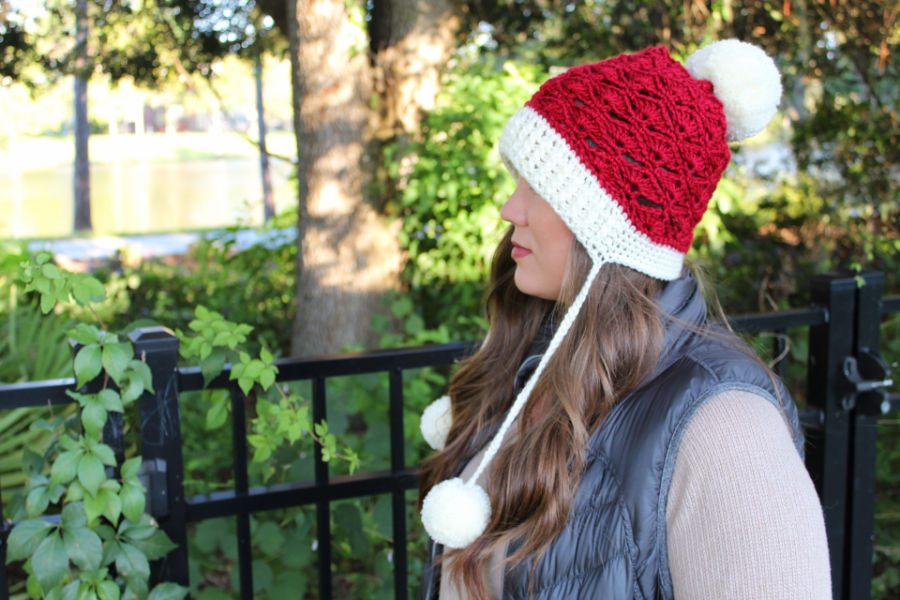 Side view of woman wearing a red and cream colored crochet slouch hat, called the Sadie Slouch. 