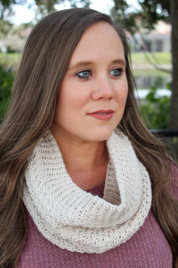 Woman wearing a cream colored crochet cowl, called the Camellia Cowl. 