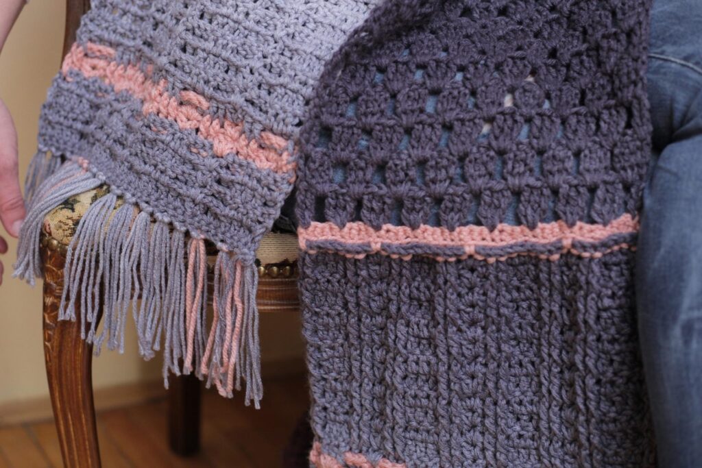 Close up photo of the fringe on the oversized crochet scarf. 