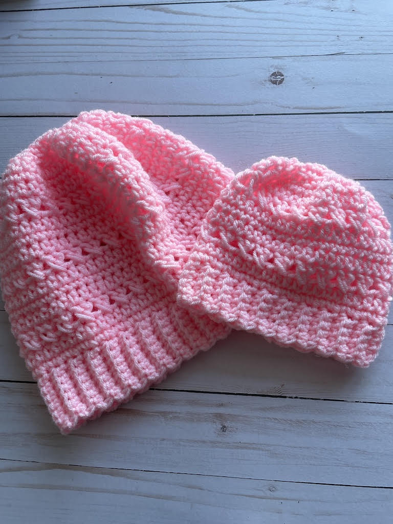 Close up photo of two crochet beanies. 