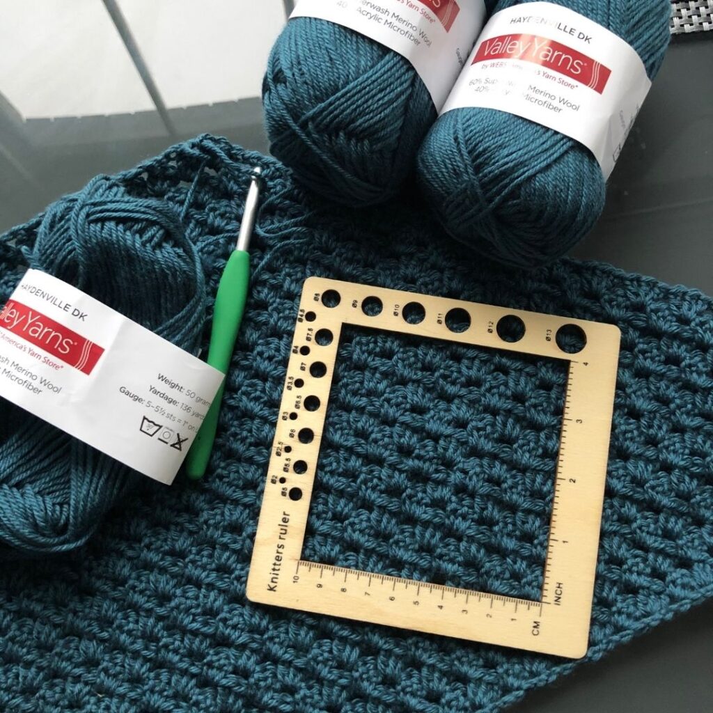 Flat lay image of the yarn and supplies used to create the Nain crochet sweater. 