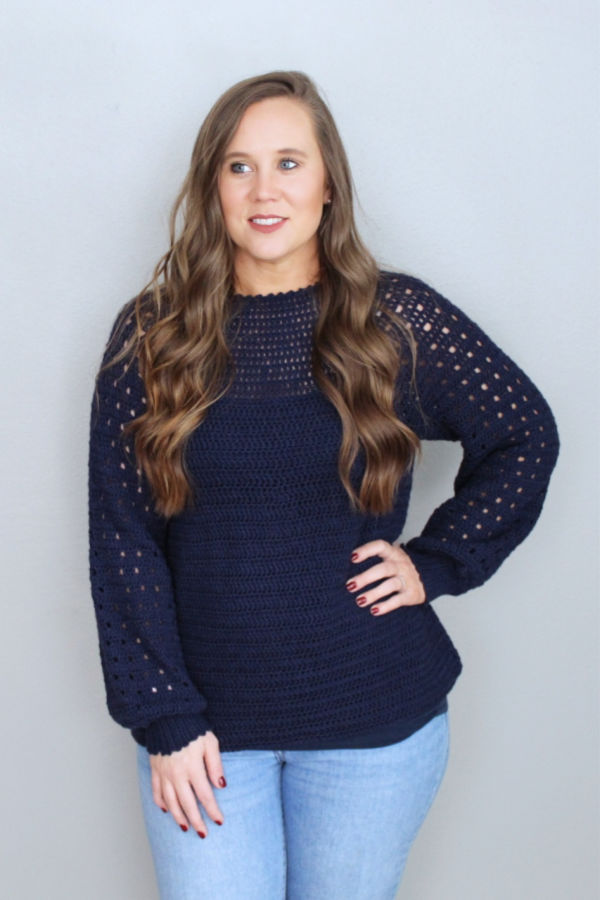 Woman wearing a navy blue crochet sweater, called the Plumbago Sweater.
