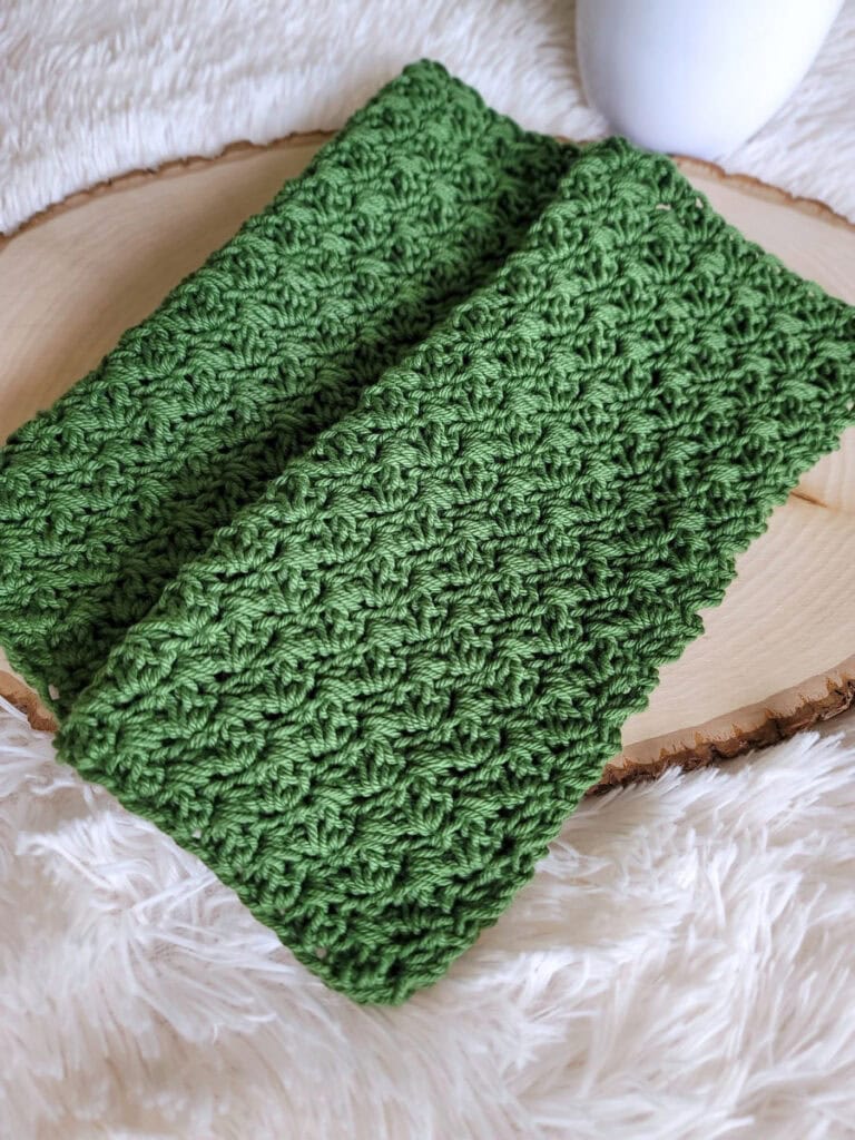 Two green crochet washcloths.