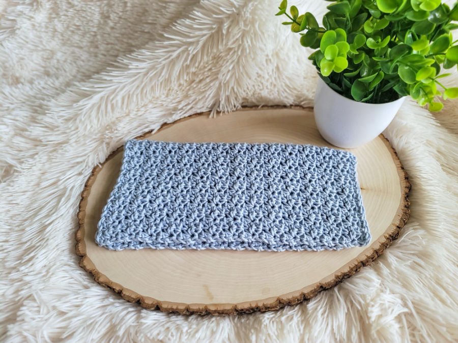 Light blue crochet washcloth, called the Camellia Washcloth. 