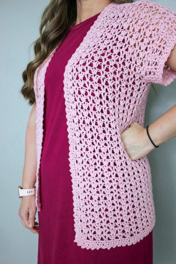 Close up image of pink, short sleeved crochet cardigan, called the Katie Cardi.