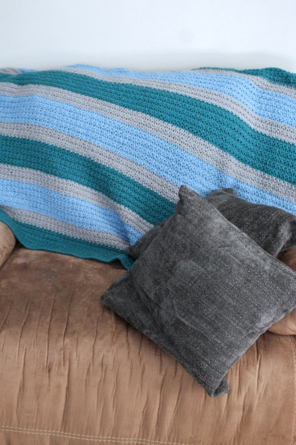 Crochet blanket draped over a couch. 
