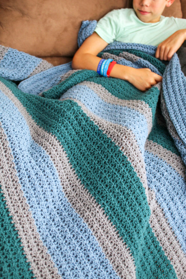 Crochet Blanket in blue, green, and silver. 