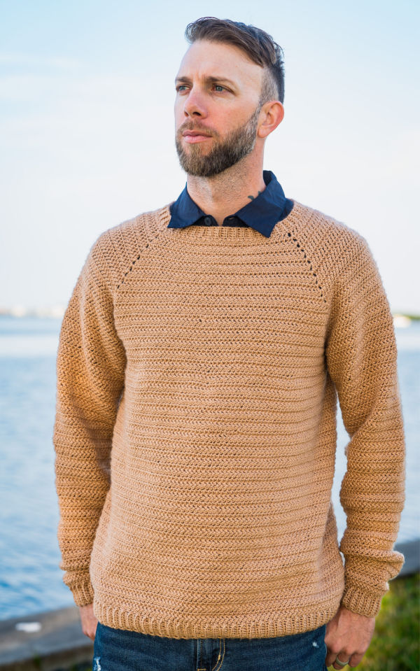 Men's crochet raglan sweater being worn with a collared shirt underneath. 