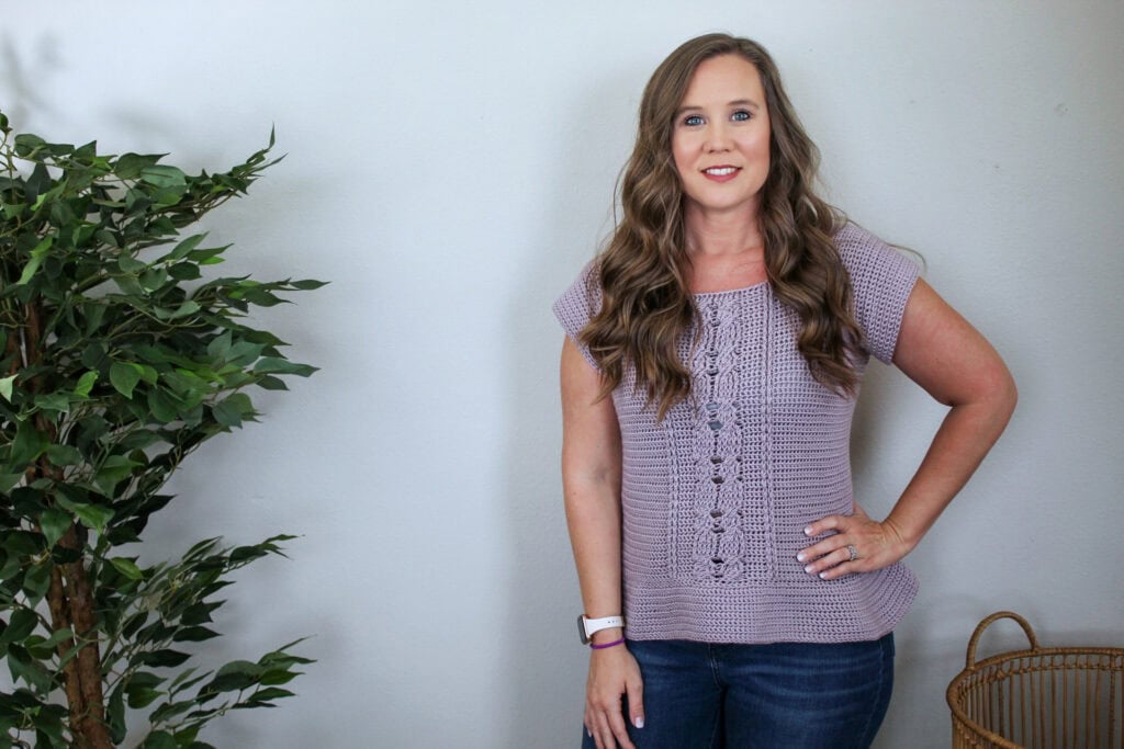 Woman wearing a crochet cabled peplum tee. 