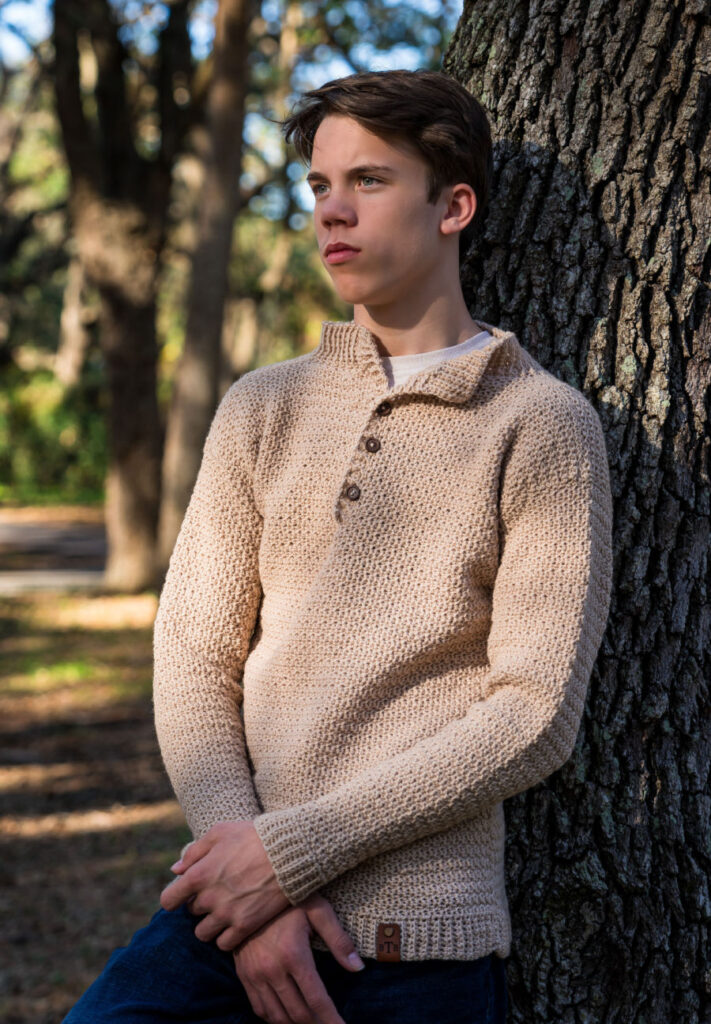 Young man wearing a men's crochet sweater called the Bramley Sweater. 