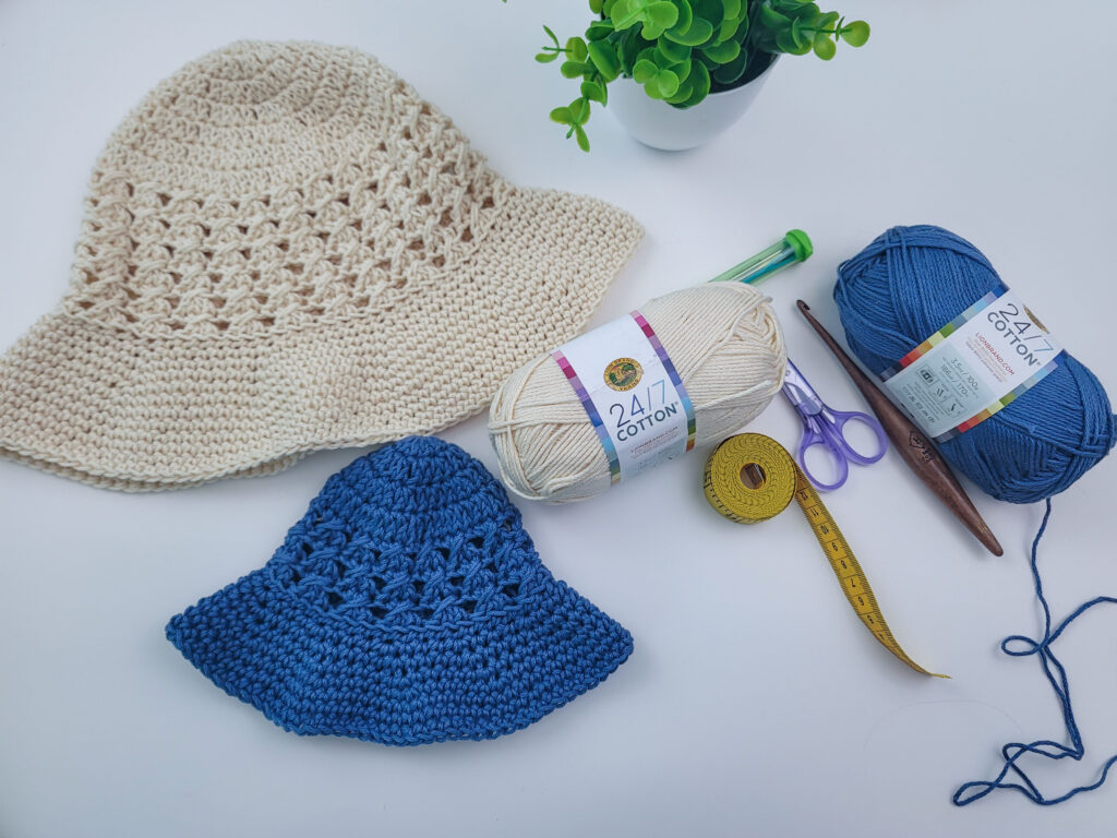 Flat lay of two crochet sun hats with all of the materials needed to make them. 