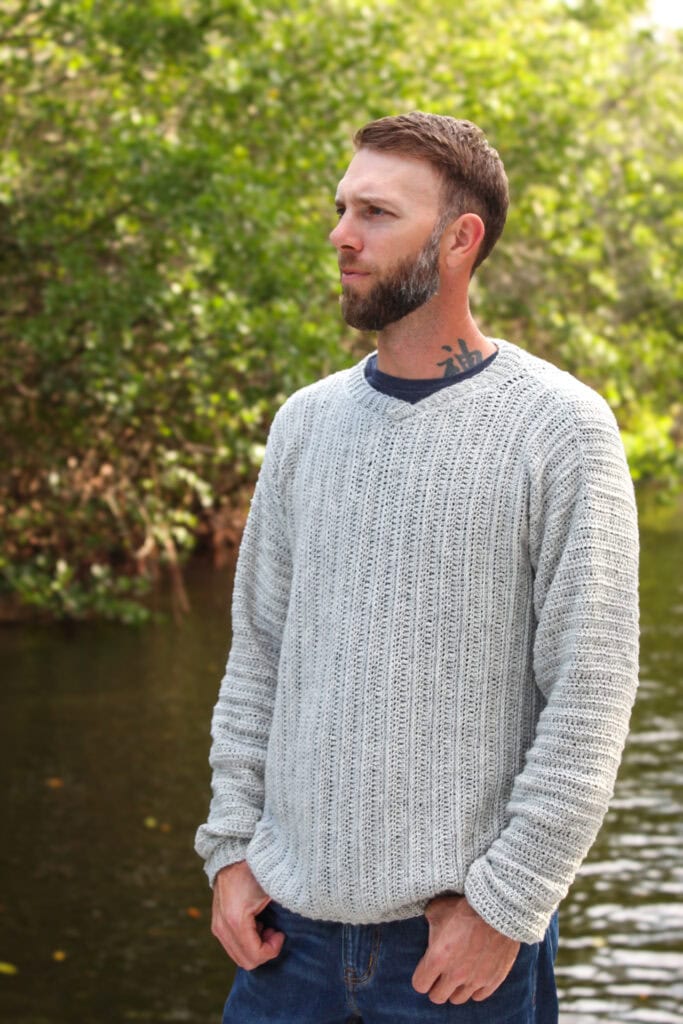 Man wearing a men's V-neck crochet sweater.