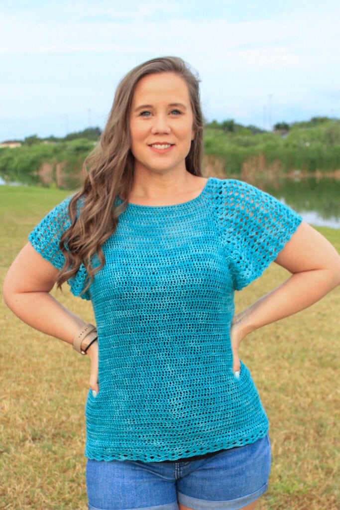 Woman wearing a summer crochet top called the Rosie Tee.