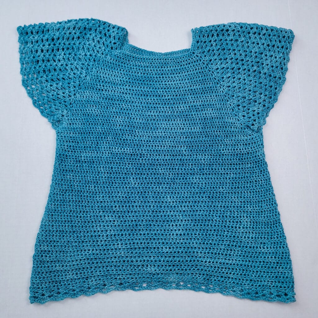 Flat lay of the summer crochet top called the Rosie Tee.