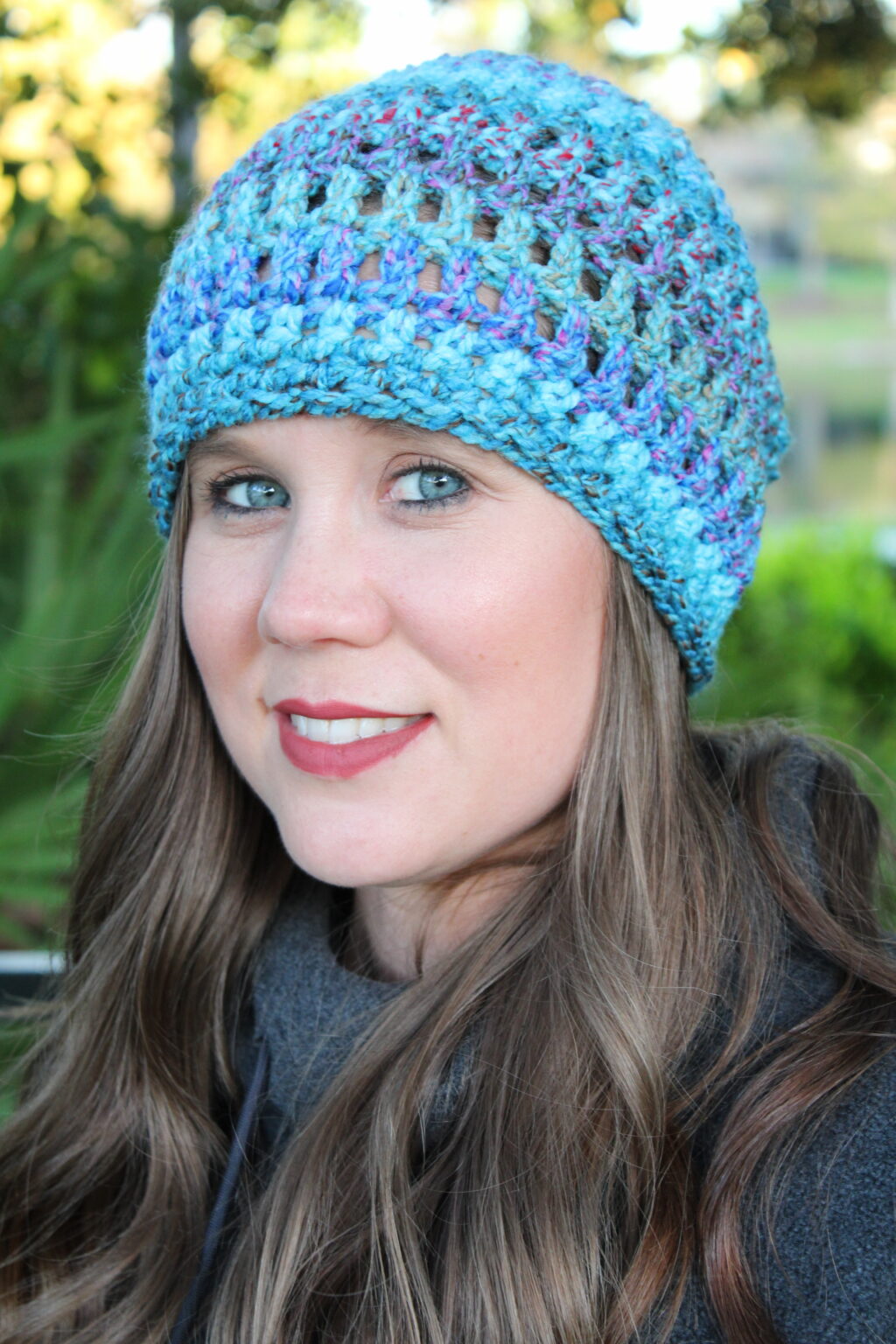 Woman wearing a blue chunky crochet slouch hat.