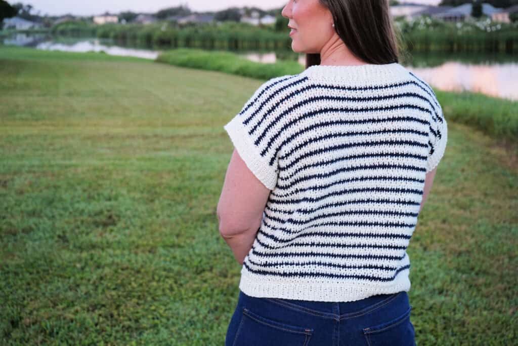 Back view of woman wearing a short-sleeved crochet sweater.
